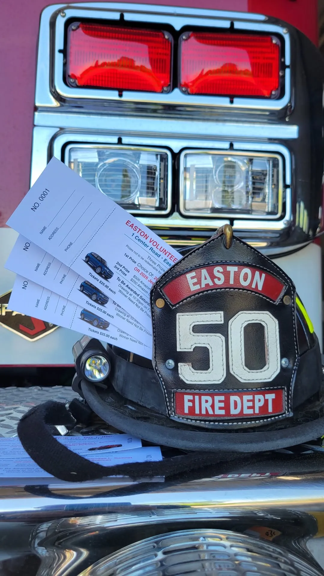 Easton Fire Department helmet with Jeep raffle tickets fanned out in front of a fire engine